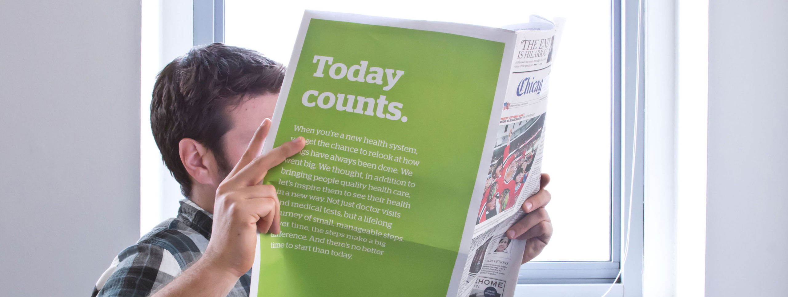Presence Health case study hero image. A man is reading a paper with the words Today counts in bold on the back page